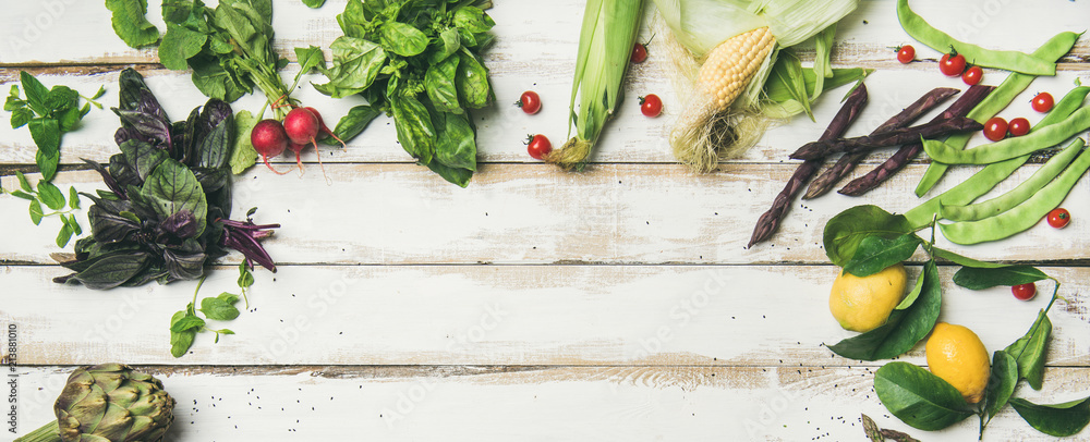 健康的夏季纯素食原料。白色餐桌背面平坦地摆放着五颜六色的蔬菜和绿色蔬菜
