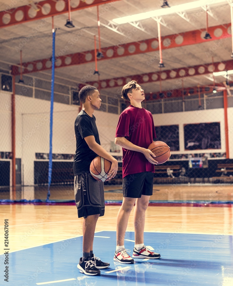 十几岁的男孩在球场上拿着篮球，团队和抱负的概念