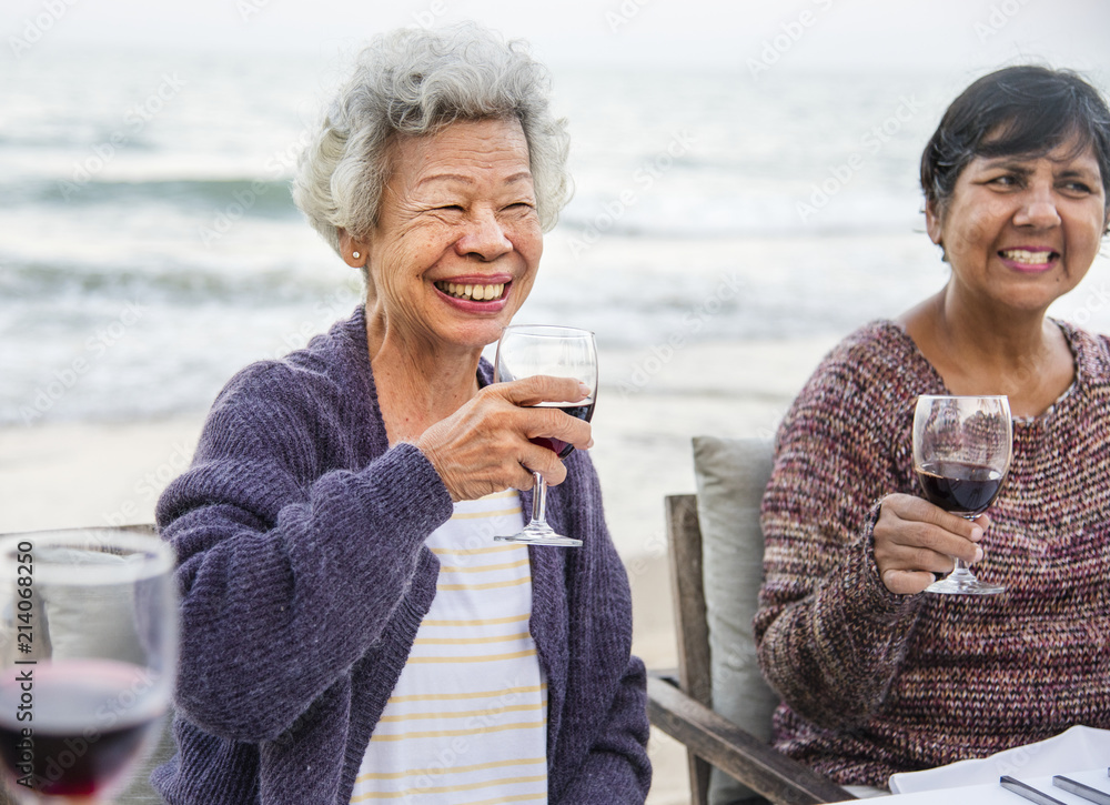 老年人在海滩上用红酒敬酒