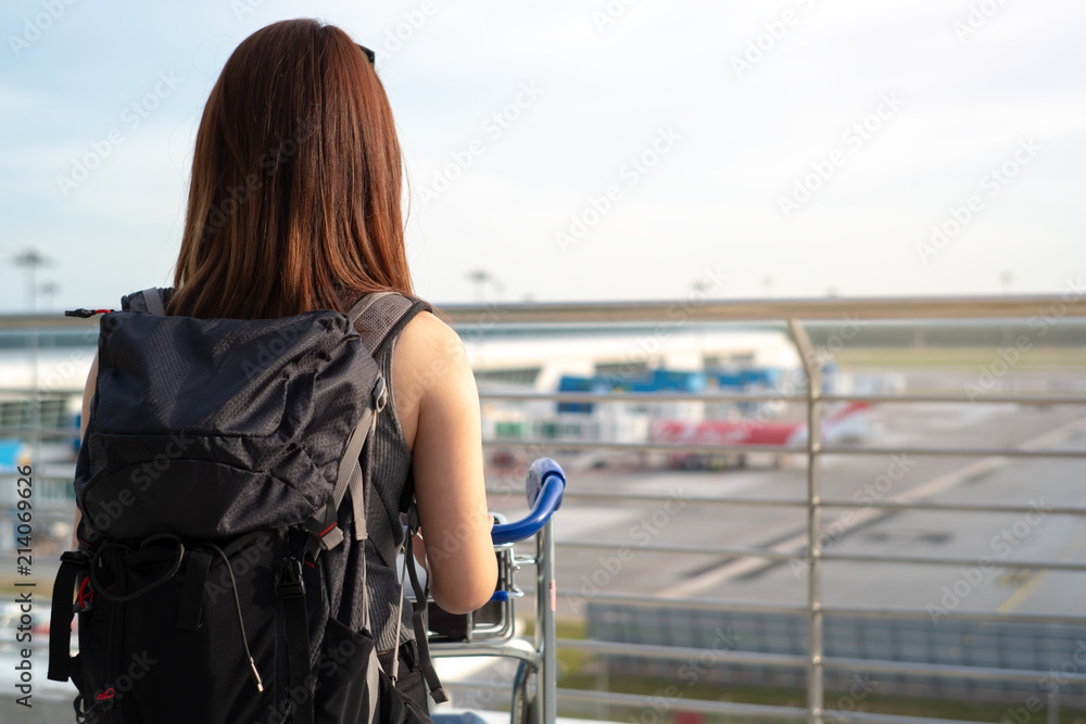 之前在登机口等待时，站在机场码头看飞机的旅游游客