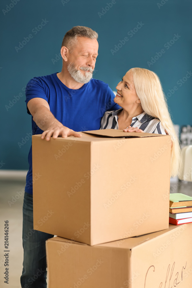 在新家搬箱子的成熟夫妇