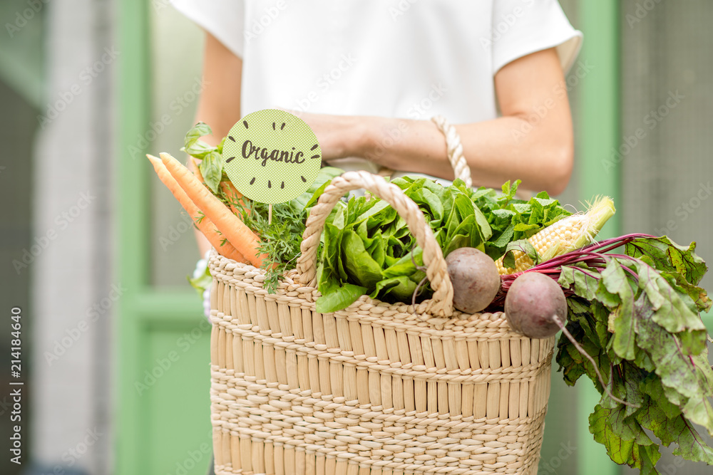 装满新鲜有机蔬菜的手提袋，绿色b上有当地市场的绿色贴纸