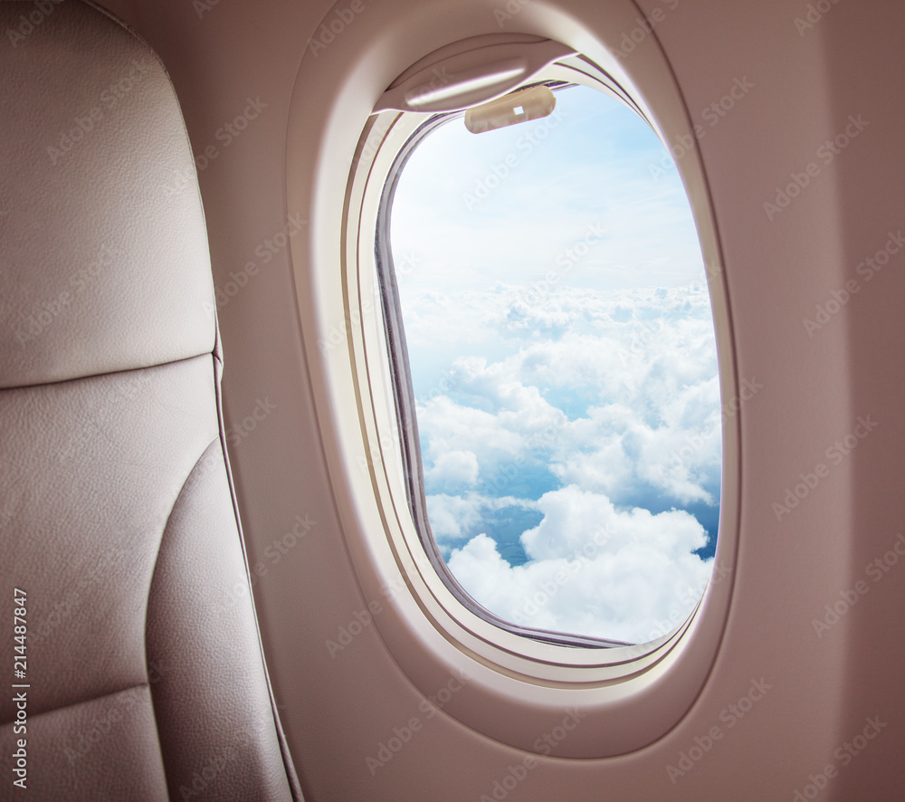 飞机内部，窗户可以看到云朵。