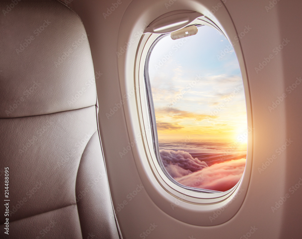 飞机内部，从窗户可以看到云层上方的日落。