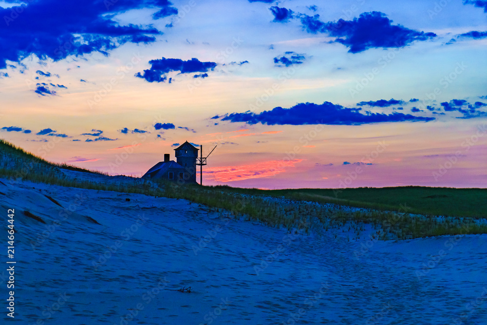 日落时分的房子，坐落在美国马萨诸塞州科德角普罗文斯特兰的沙丘和草地之间。