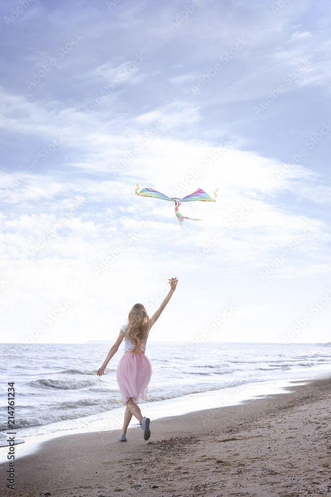 美丽的年轻女子在海边放风筝
