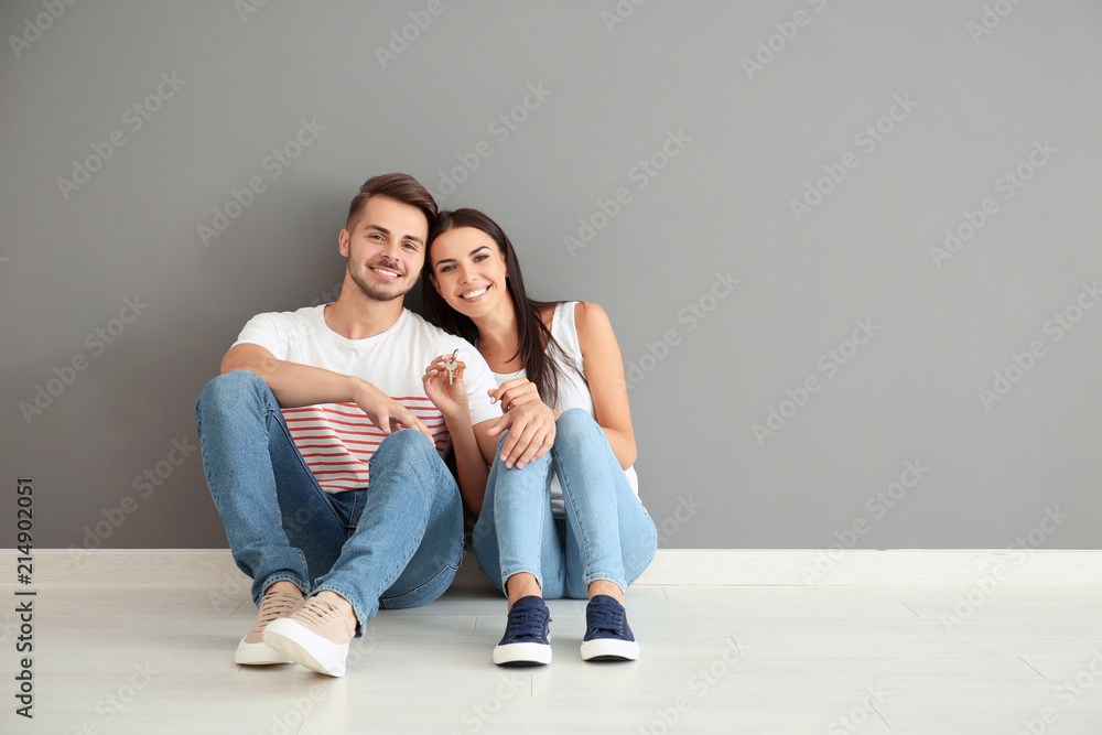 年轻幸福的夫妇，钥匙坐在新家的地板上