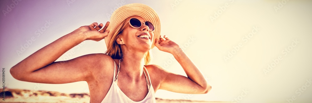 海滩上戴着墨镜和帽子的快乐女人