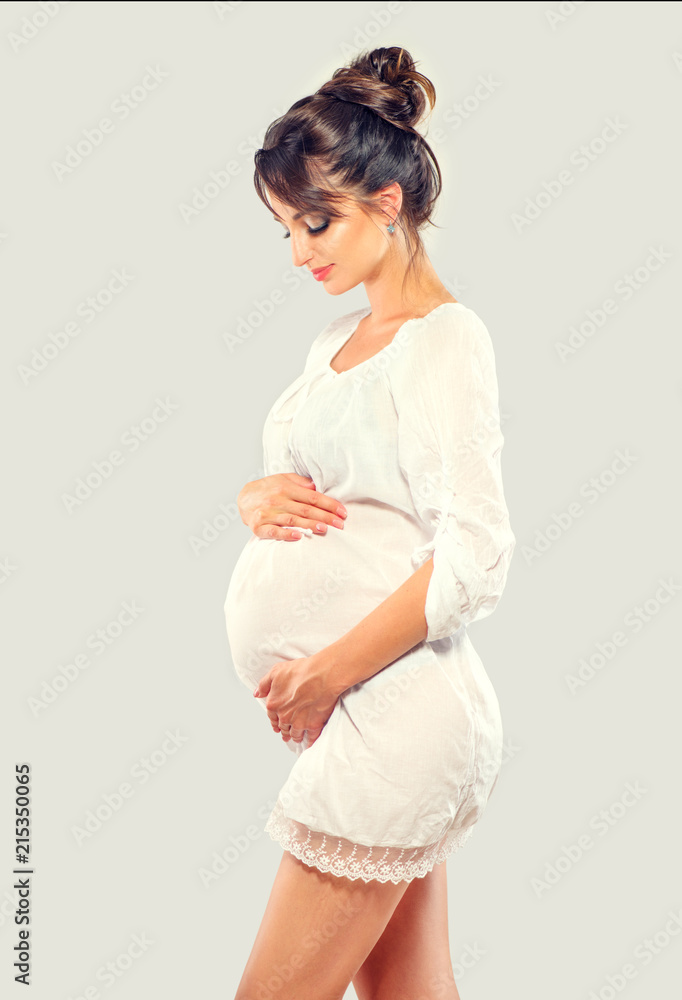 怀孕快乐的女人抚摸她的肚子。怀孕美丽的年轻母亲画像，抚摸她的肚子
