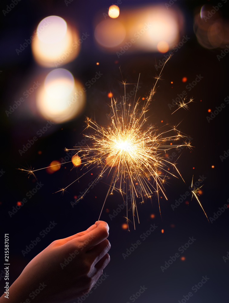 Hand holding a burning sparkler
