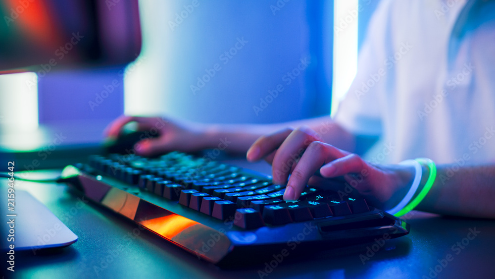 玩家在键盘上玩电子游戏并使用鼠标时的手特写。时尚