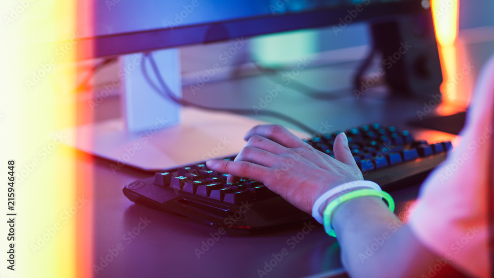 在键盘上玩视频游戏并使用鼠标的玩家的手特写。时尚