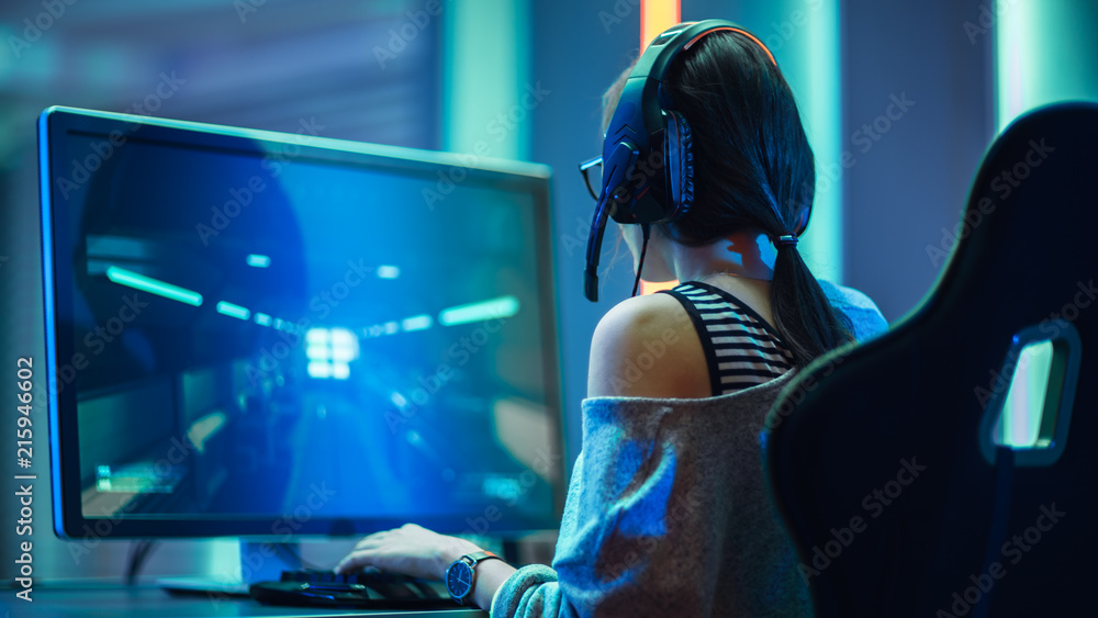 美丽的职业玩家女孩在个人电脑上玩FPS视频游戏的镜头，休闲可爱