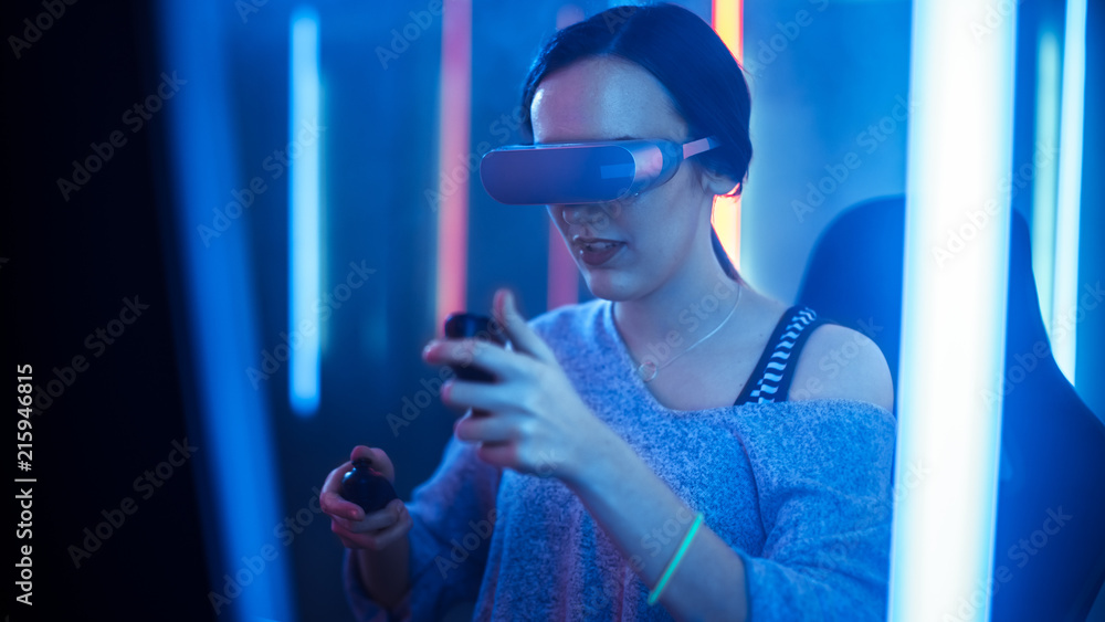 美丽的职业游戏女孩戴着虚拟现实耳机在网络视频游戏中玩，手势Usin