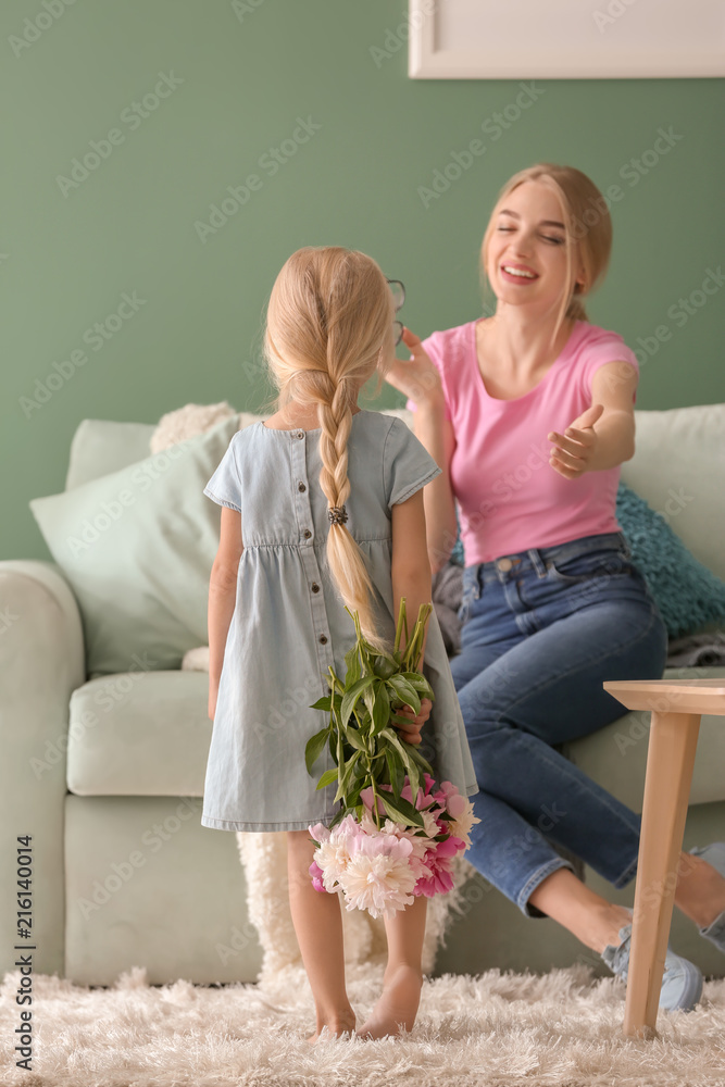 可爱的小女孩在家里用鲜花问候妈妈