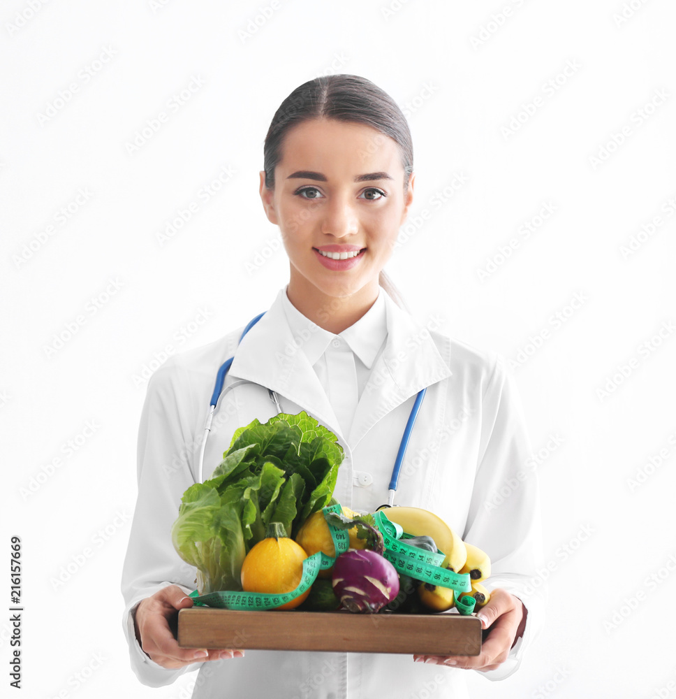 女营养师拿着白底健康蔬菜和水果的木板