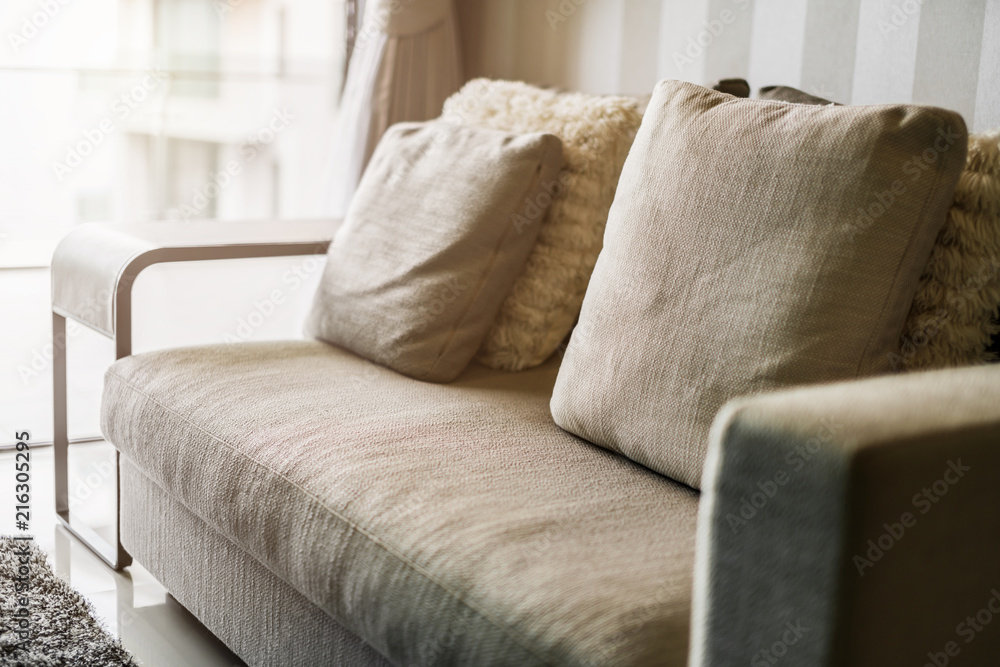 美丽的休闲软沙发，带装饰枕头，白色简洁的起居区
