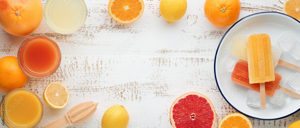 自制橙色、柠檬冰棍和石黑色背景的柑橘类水果。