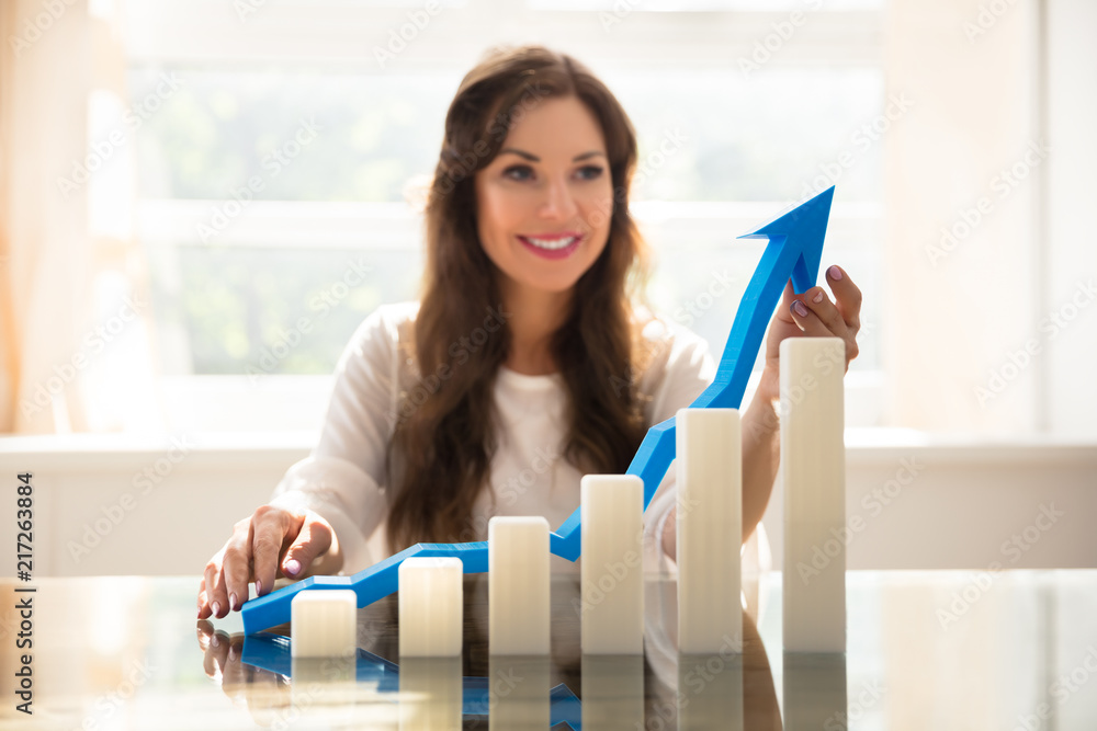 Increasing Graph In Front Of Businesswoman Holding Arrow