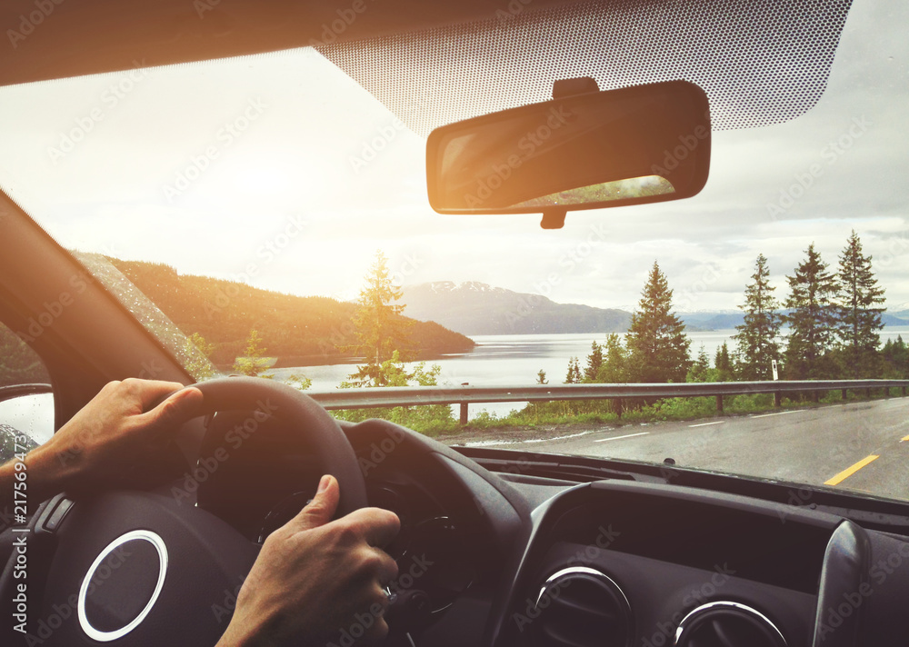 在挪威驾驶汽车，公路旅行，驾驶员的手放在方向盘上