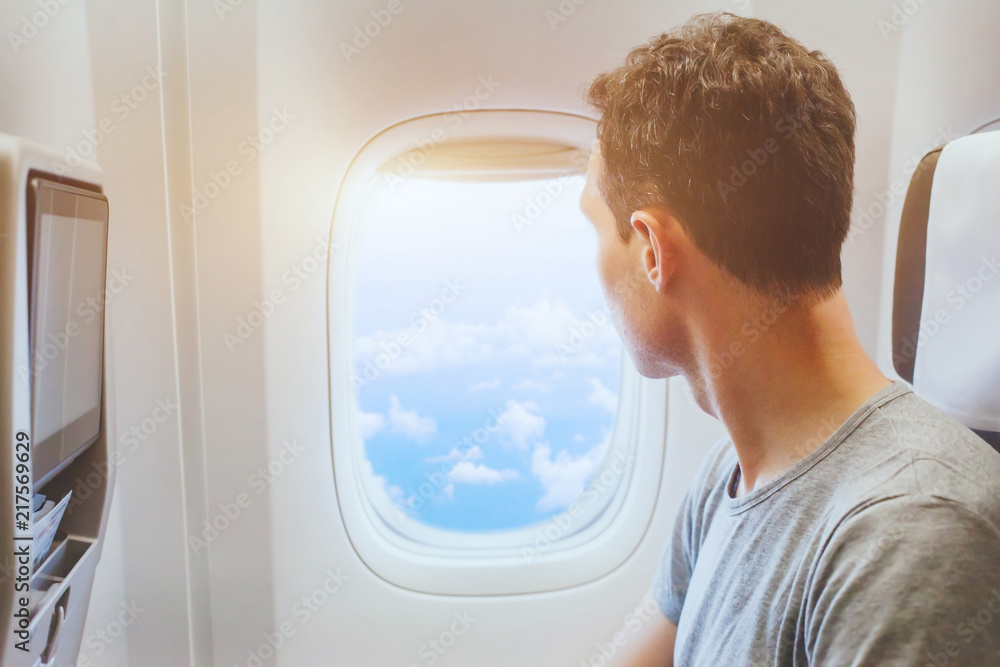 飞机乘客看窗，国际旅行，快乐男人游客享受空中飞行
