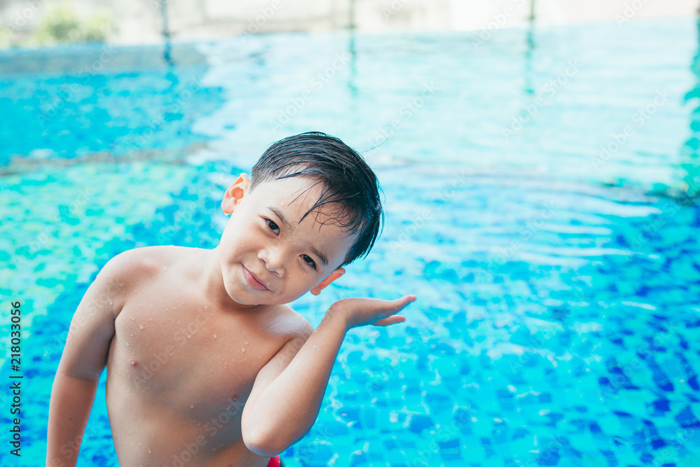 可爱的亚洲孩子在游泳池里洗耳朵