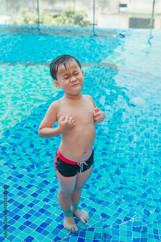 压力亚洲男孩在泳池背景上抓挠身体。夏季概念