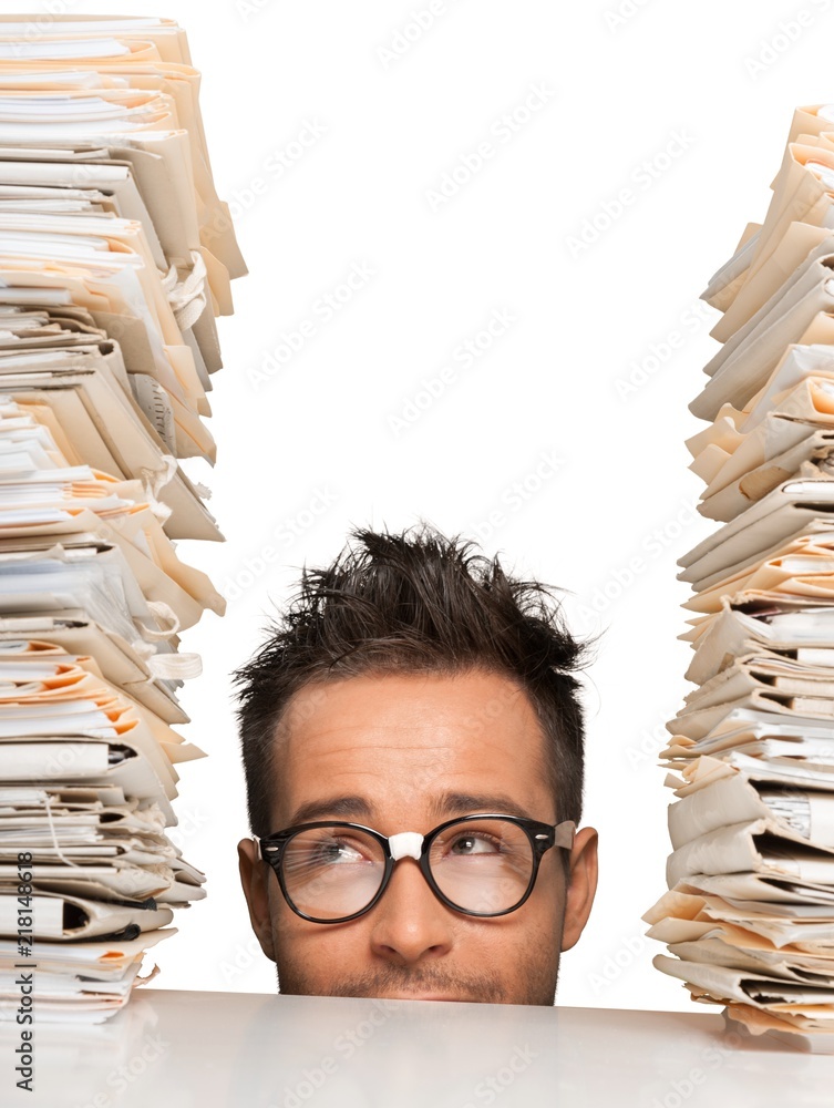 Closeup of a Hiding Businessman Looking at Stack of Folders