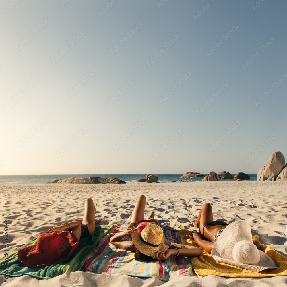 戴着太阳帽在海滩放松的女人