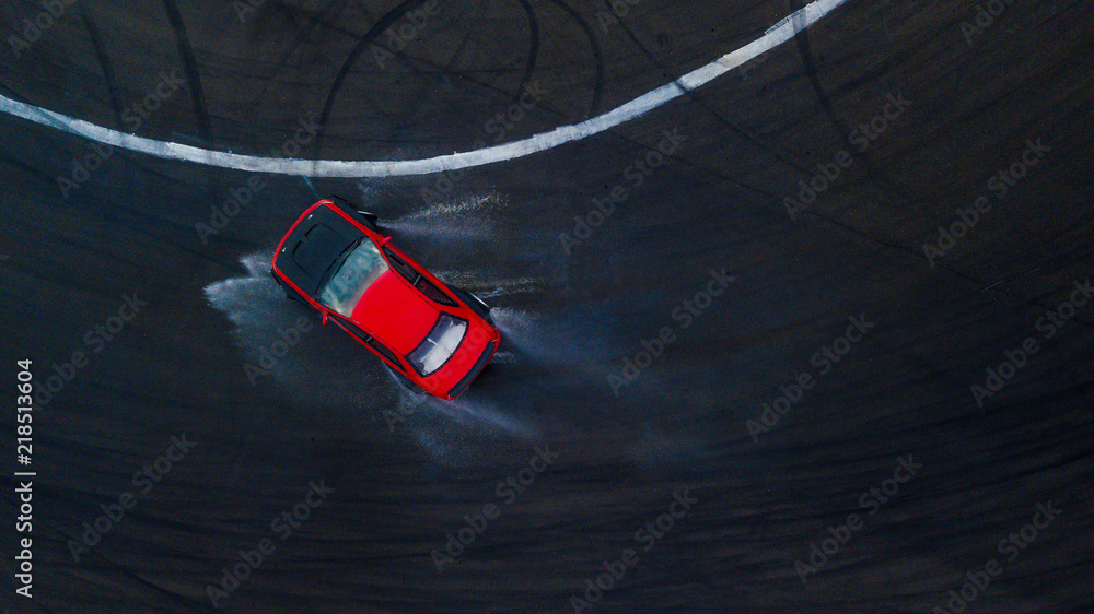 空中俯视图职业车手在潮湿的沥青赛道上漂移的红色赛车，溅水，Au