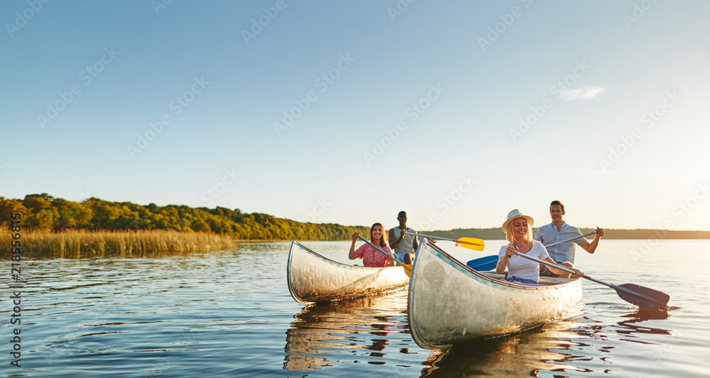 微笑的年轻朋友一起在夏天的湖面上划独木舟
