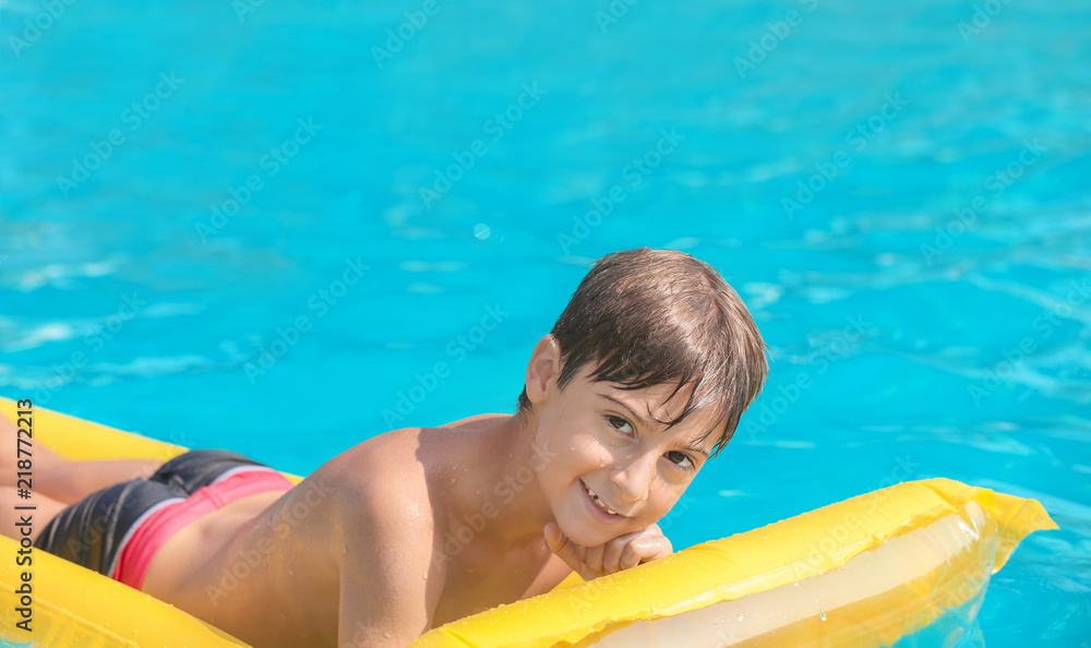 夏日游泳池充气床垫上的可爱男孩