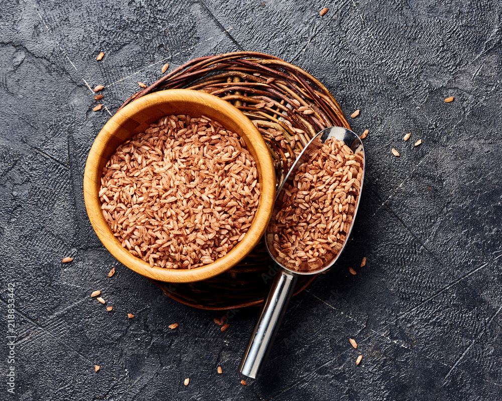 黑色背景木碗中的野生糙米。谷物俯视图。