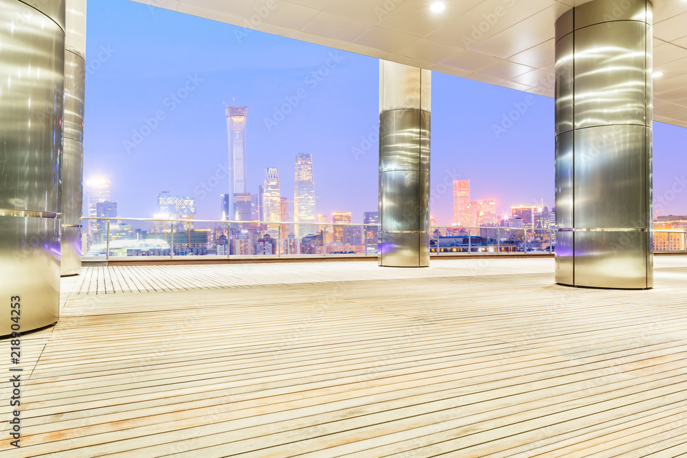 北京夜晚的木方地板与现代城市天际线