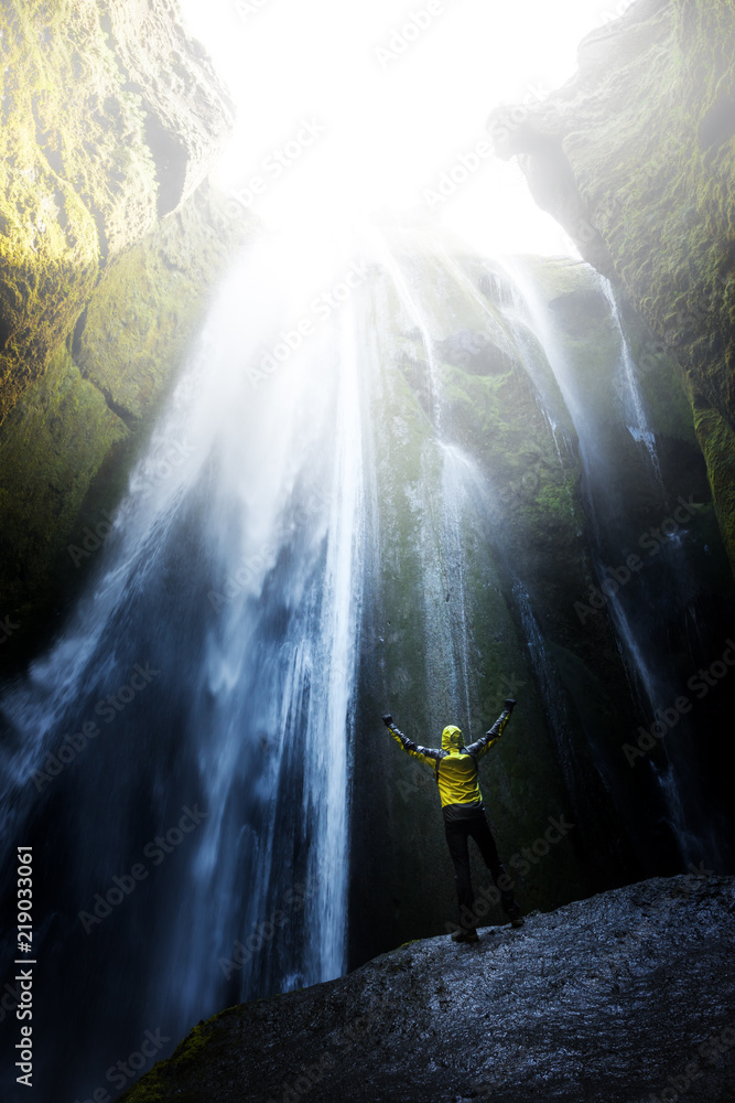 Man in the cave near the Gljufrabui waterfall, Iceland, Europe