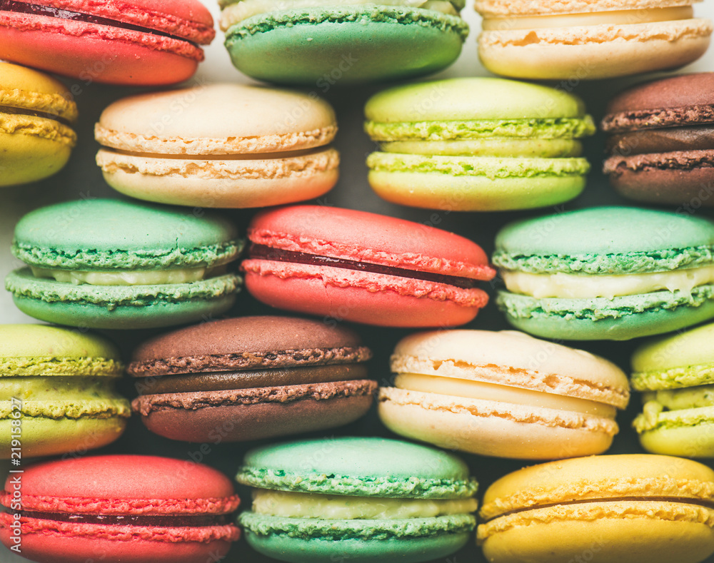 一排排堆叠的彩色甜法式马卡龙饼干，俯视图