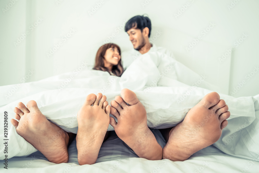 幸福的年轻夫妇在家里的卧室里放松。