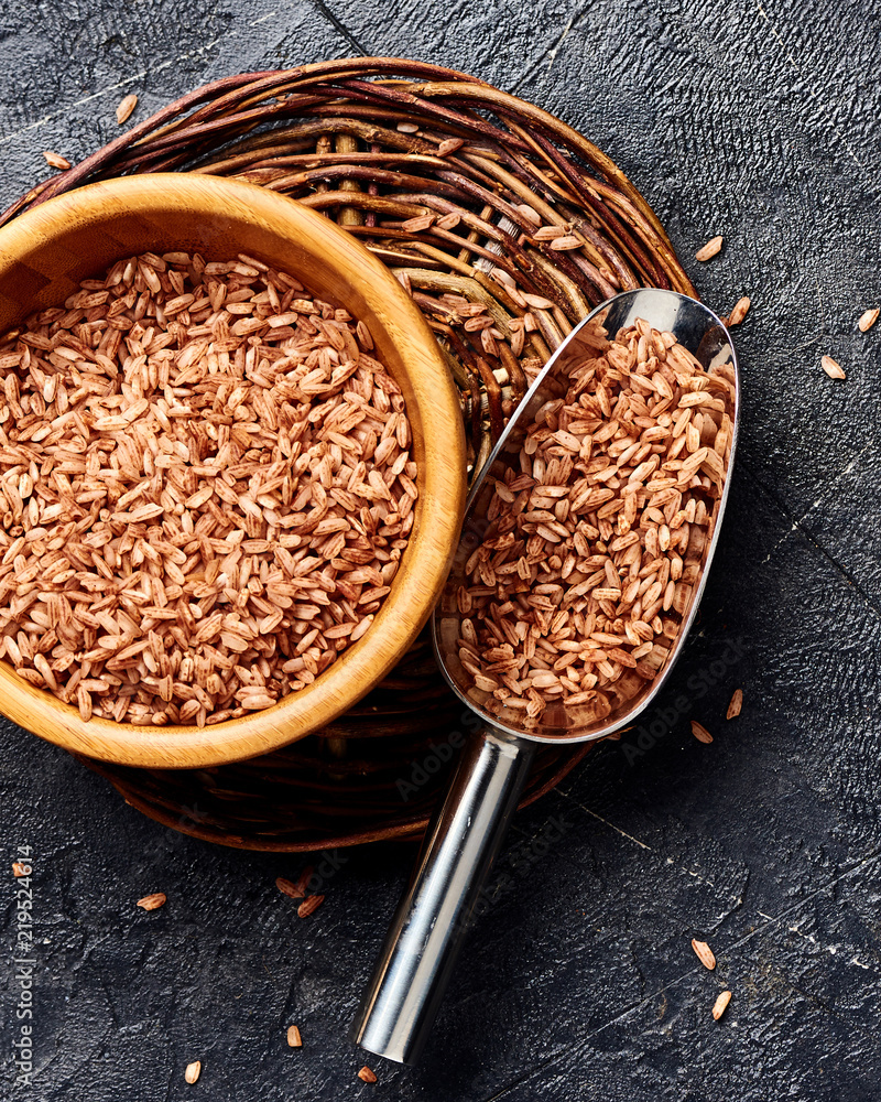 黑色背景木碗中的野生糙米。谷物俯视图。