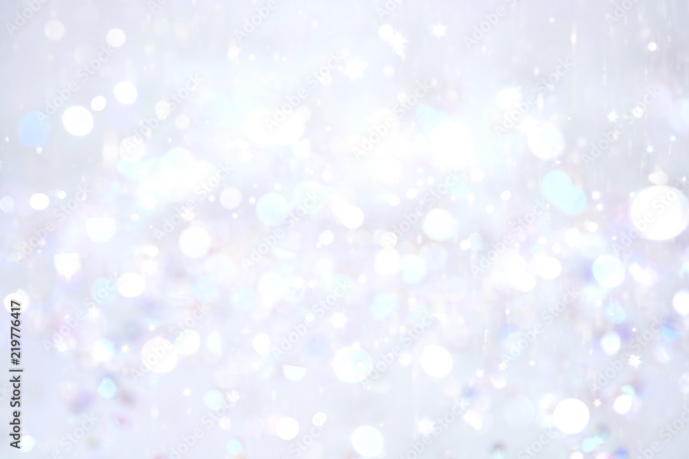 淡银灰蓝色调的冬季雪花模糊背景。飘落的散焦雪带着美丽的灯光