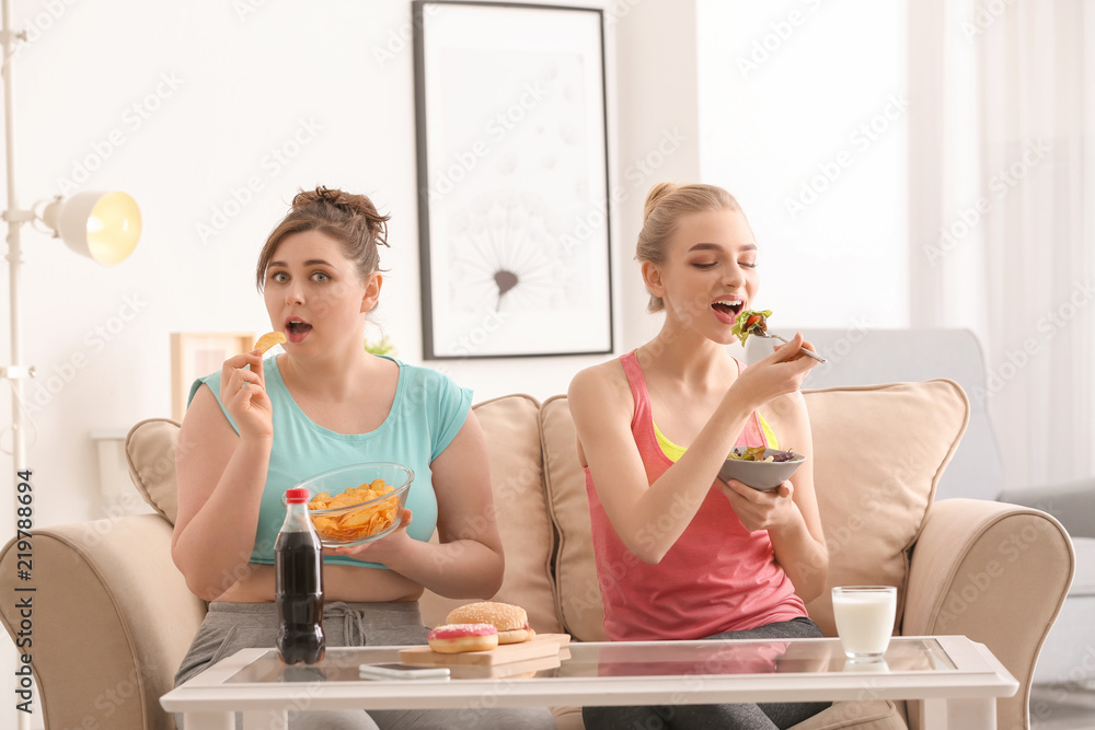 女性在家吃饭。在饮食和不健康食物之间做出选择