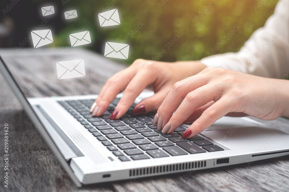 商务女性使用笔记本电脑发送带有电子邮件图标、电子邮件和通信概念的电子邮件。