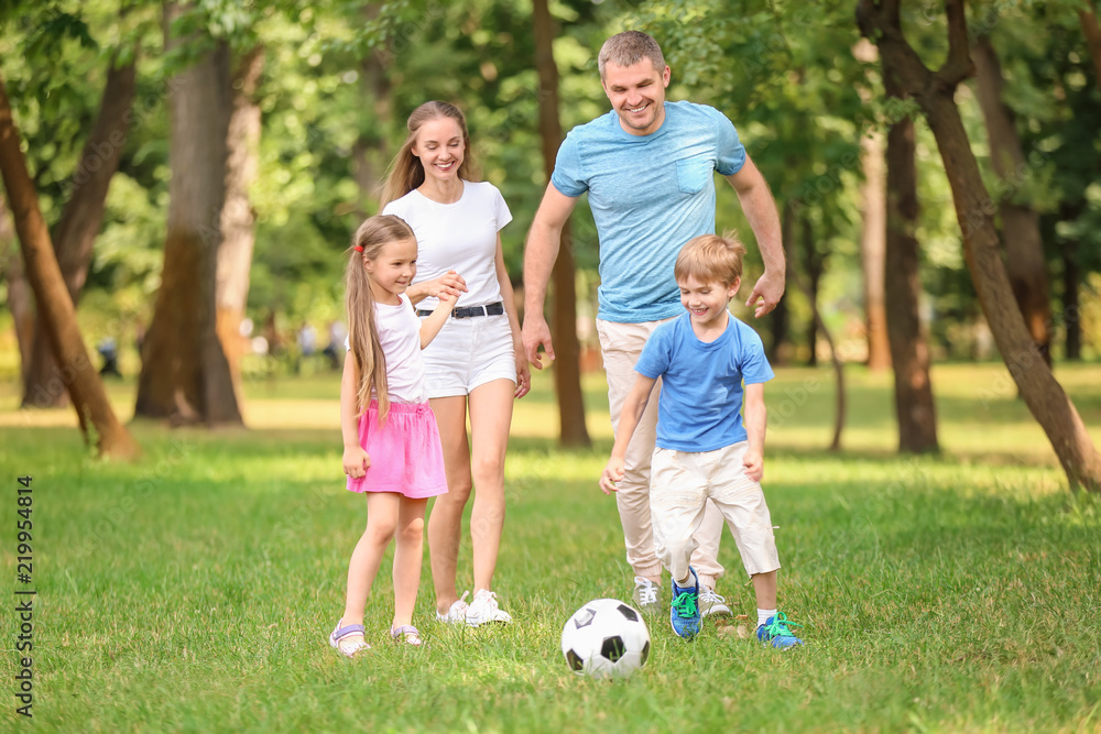 夏日快乐的一家人在公园踢足球