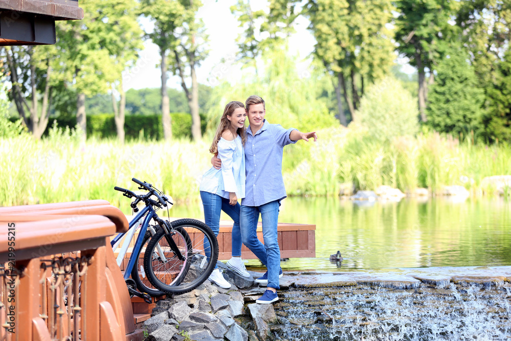 年轻夫妇骑自行车后在河边休息