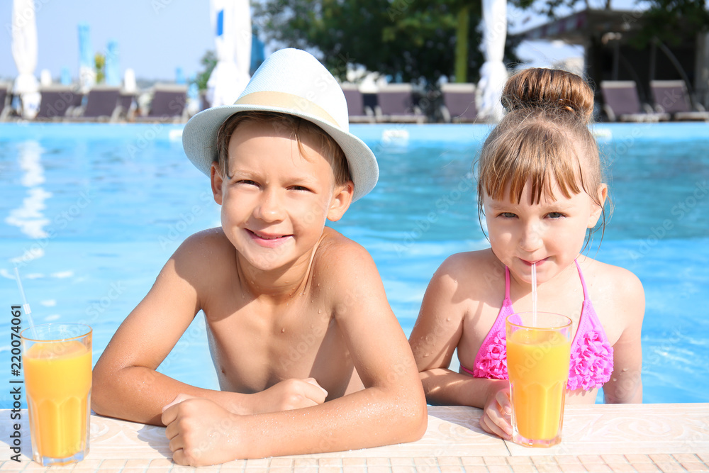 夏日泳池里带着几杯果汁的可爱孩子