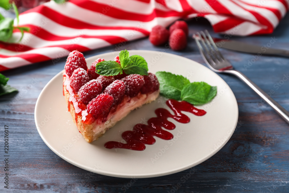 木桌上摆着一块美味的树莓芝士蛋糕