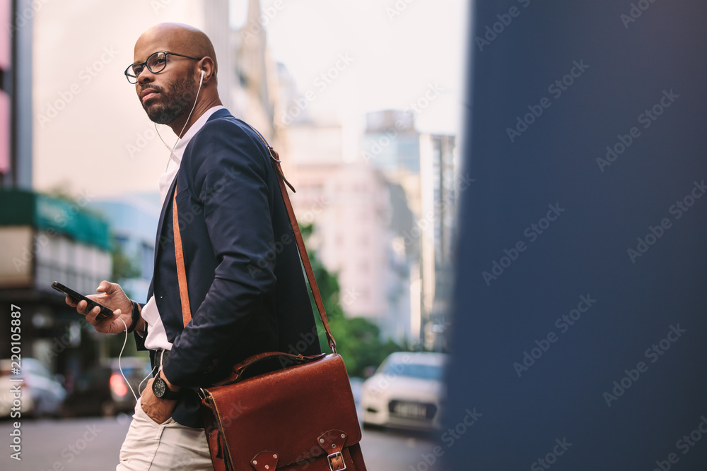 African businessman with bag walking on the street