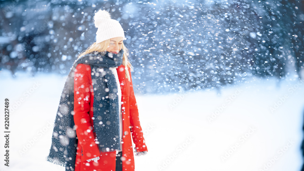 Portrait Shot of a Young Blonde Woman in the Red Coat with a Scarf Standing in Her Backyard while Sn