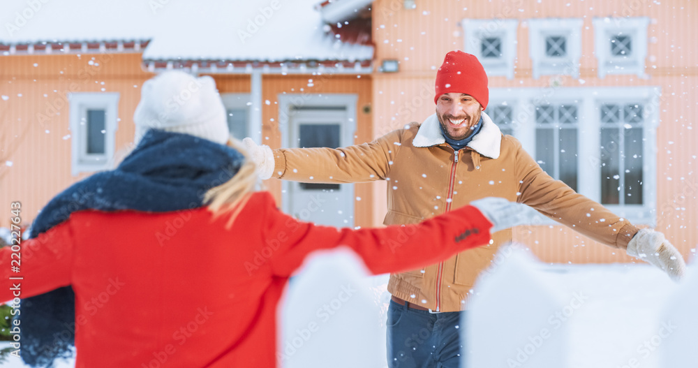 Handsome Young Man Meets His Fiance Coming Home, they Embrace Happily, Snow Falls on them. Couple in