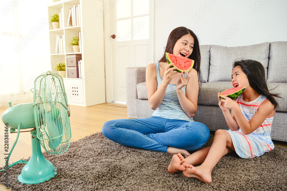 mom and kid eating watermelon happily.