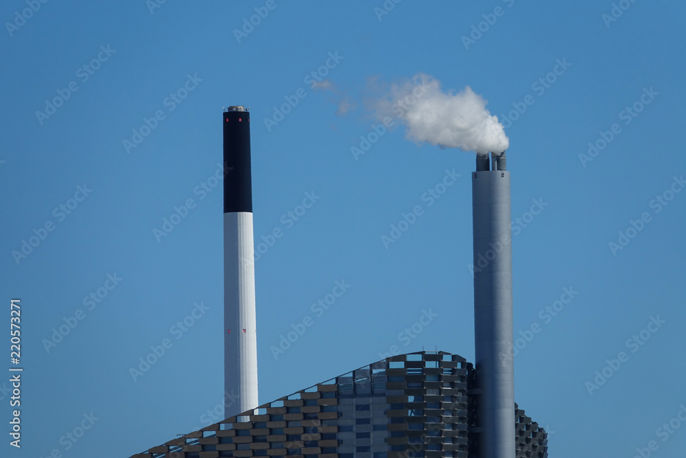 高耸的工业烟囱将有害废气吹向晴朗的蓝天。